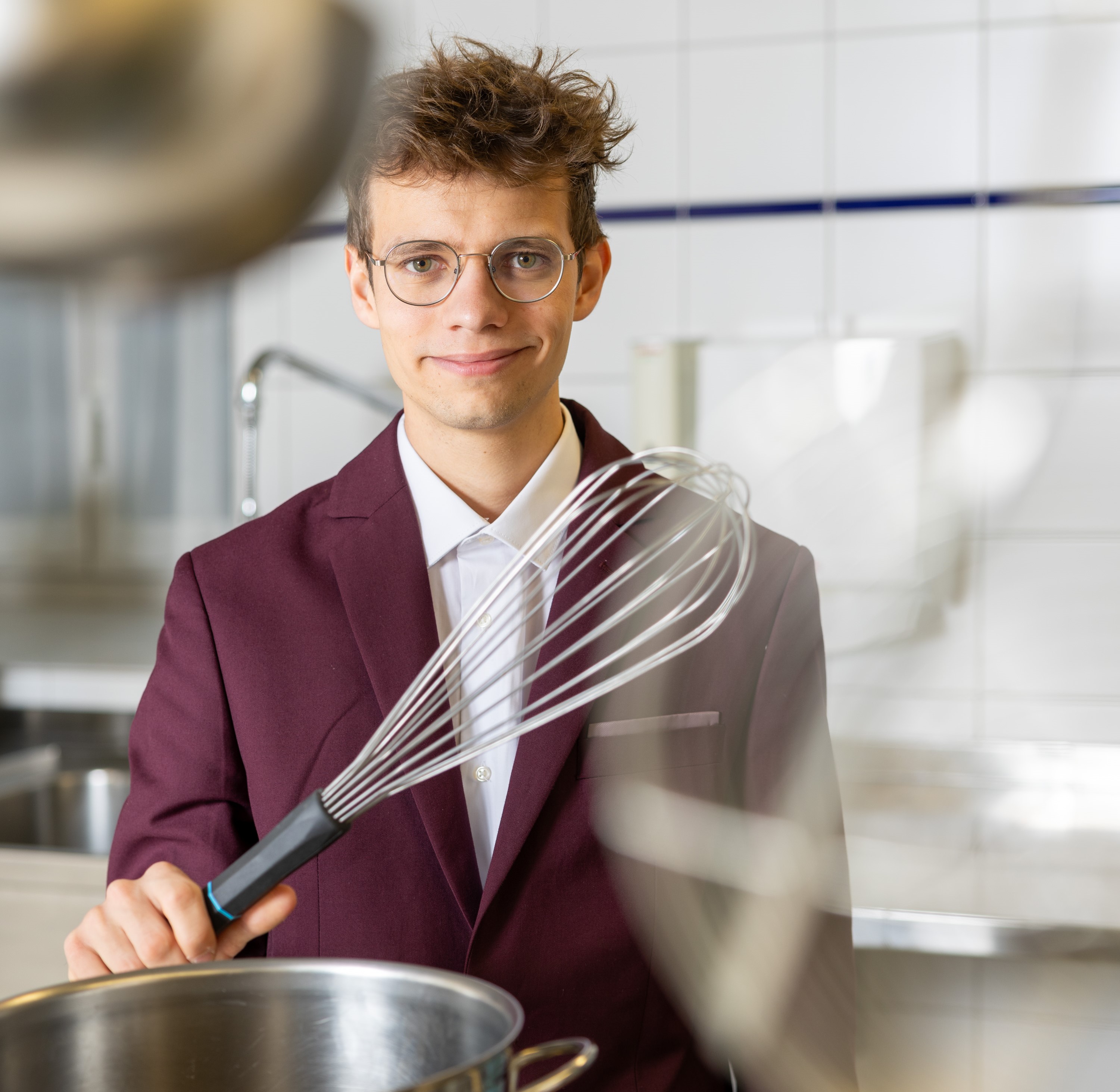 Lukas Adam mit Schneebesen in einer Küche